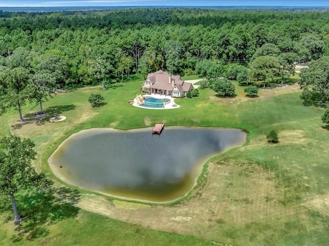 birds eye view of property with a wooded view and a water view