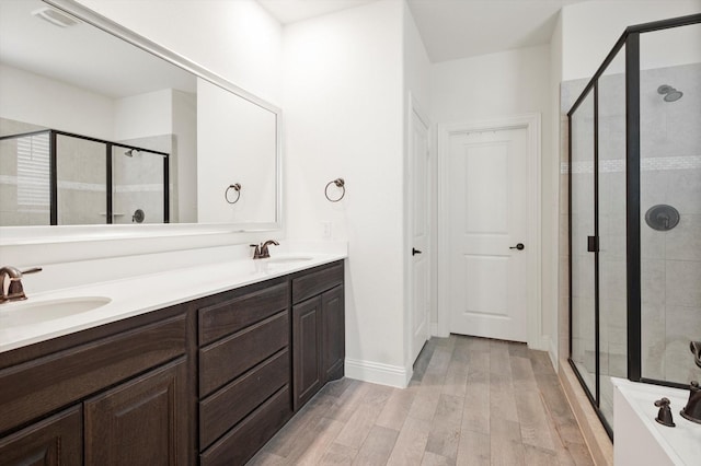 bathroom featuring vanity, wood-type flooring, and walk in shower