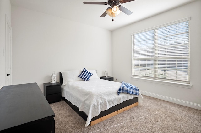 carpeted bedroom with ceiling fan and multiple windows