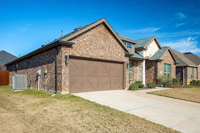 view of front of home featuring cooling unit, a garage, and a front lawn