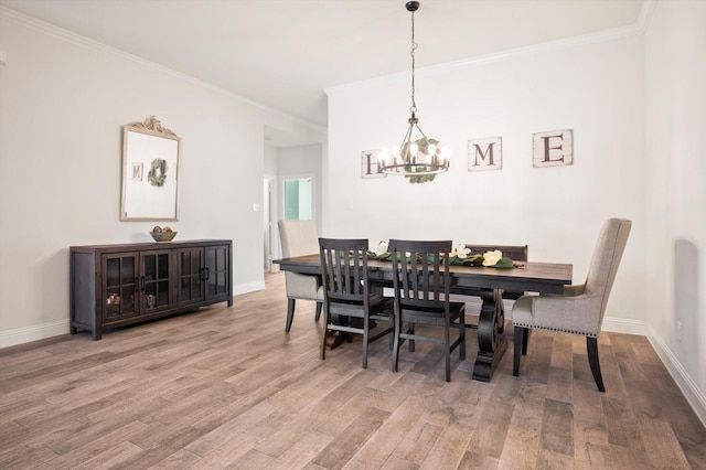 dining room with hardwood / wood-style floors, a notable chandelier, and crown molding