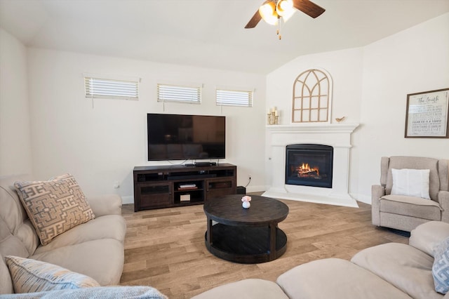 living room with ceiling fan, wood-type flooring, and lofted ceiling