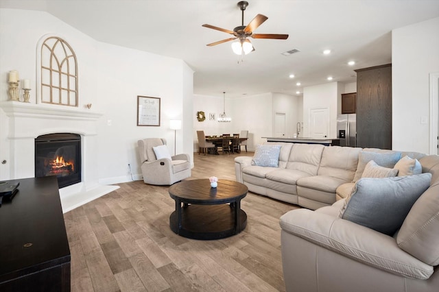 living room featuring light hardwood / wood-style flooring and ceiling fan