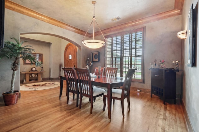 dining space with hardwood / wood-style floors and ornamental molding