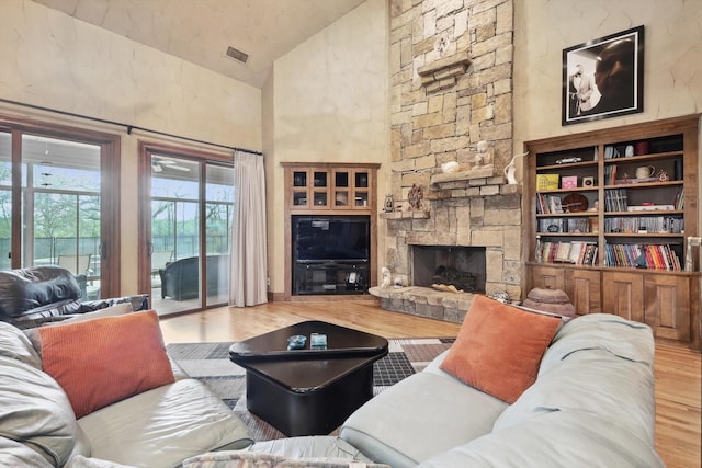 living room with a fireplace, hardwood / wood-style floors, and lofted ceiling