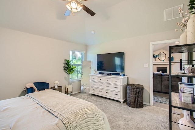 bedroom with ceiling fan, light carpet, and vaulted ceiling