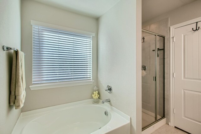 bathroom featuring tile patterned floors and independent shower and bath