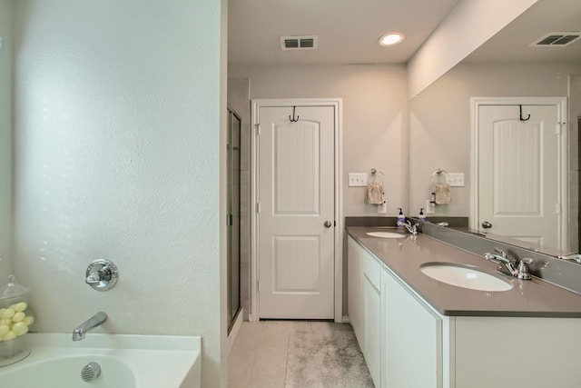 bathroom featuring plus walk in shower, tile patterned flooring, and vanity