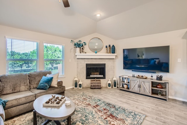 living room featuring a tiled fireplace, ceiling fan, lofted ceiling, and hardwood / wood-style flooring