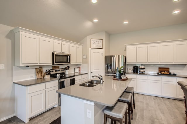 kitchen featuring a center island with sink, sink, white cabinetry, and stainless steel appliances