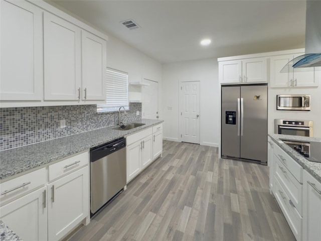 kitchen with stainless steel appliances, sink, white cabinets, and ventilation hood