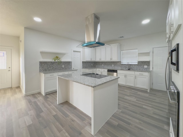 kitchen featuring white cabinetry, sink, a kitchen island, and island exhaust hood