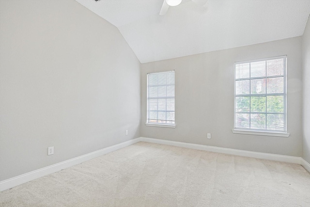 carpeted spare room featuring ceiling fan and vaulted ceiling