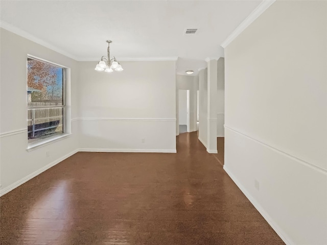 spare room featuring crown molding and an inviting chandelier