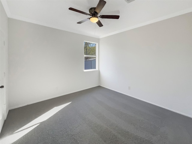 spare room featuring dark colored carpet, ceiling fan, and ornamental molding