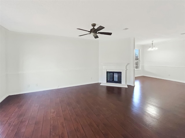 unfurnished living room with ceiling fan with notable chandelier and dark hardwood / wood-style floors