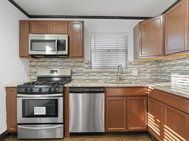 kitchen featuring light stone counters, appliances with stainless steel finishes, and sink