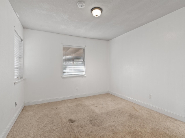 carpeted spare room featuring a textured ceiling