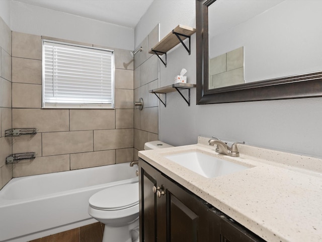 full bathroom featuring tiled shower / bath combo, vanity, and toilet