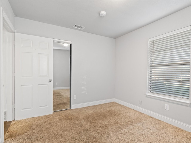 unfurnished bedroom featuring carpet floors and a closet