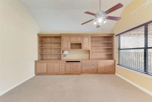 unfurnished office with ceiling fan, light colored carpet, and vaulted ceiling