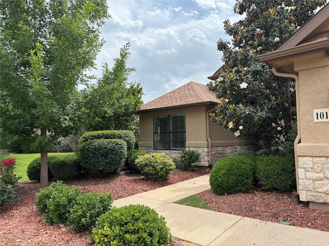 10104 Southpoint Ct, Denton, TX 76207 - view of home's exterior with stone siding, stucco siding, and a shingled roof