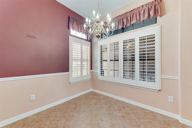 empty room featuring tile patterned flooring and an inviting chandelier