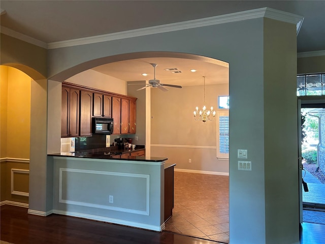 10104 Southpoint Ct, Denton, TX 76207 - kitchen featuring black microwave, dark countertops, arched walkways, ceiling fan, and crown molding