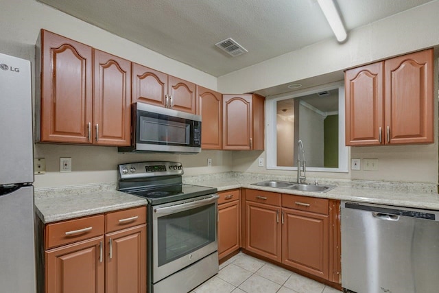 kitchen featuring light tile patterned flooring, appliances with stainless steel finishes, and sink