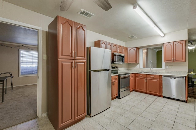 kitchen with stainless steel appliances, ceiling fan, light colored carpet, and sink