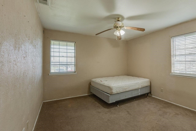 bedroom featuring multiple windows, carpet flooring, and ceiling fan