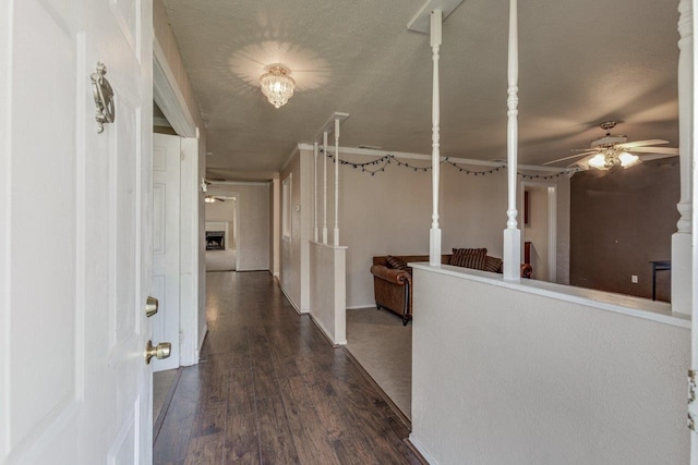 hallway featuring a textured ceiling and dark hardwood / wood-style floors