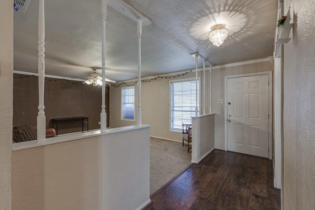 interior space with a textured ceiling, ceiling fan with notable chandelier, and dark wood-type flooring