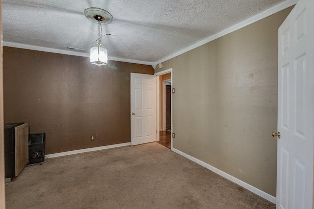 carpeted spare room featuring crown molding and a textured ceiling