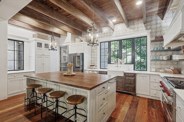 kitchen with white cabinetry, appliances with stainless steel finishes, a chandelier, and a kitchen island