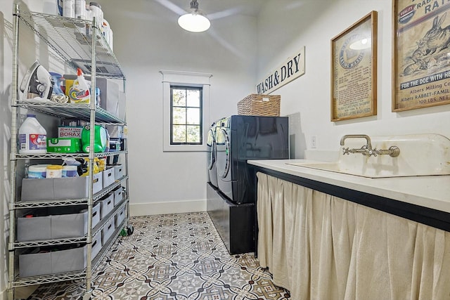 washroom featuring sink, light tile patterned floors, and independent washer and dryer