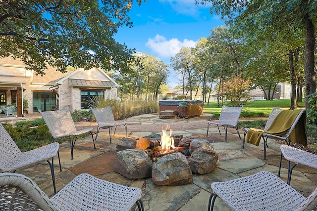 view of patio / terrace featuring a hot tub and a fire pit