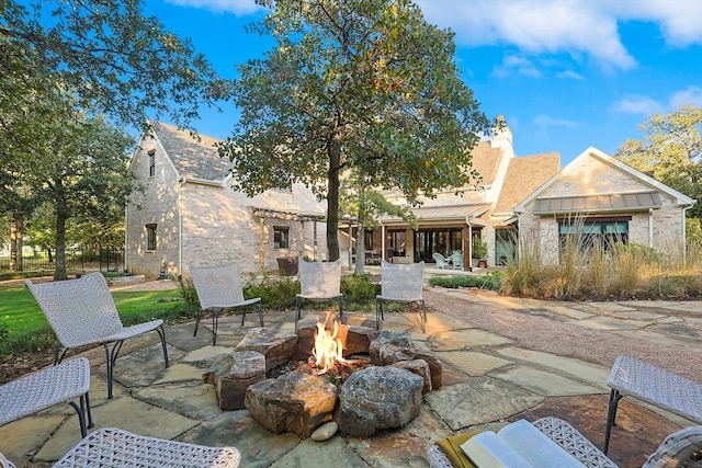 rear view of house featuring an outdoor fire pit and a patio