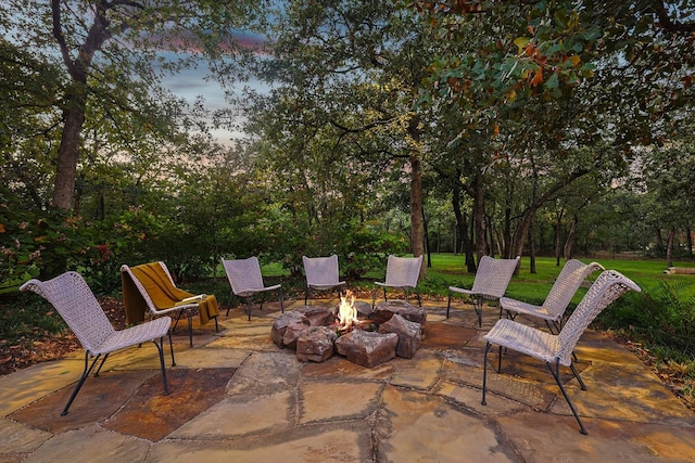 patio terrace at dusk featuring an outdoor fire pit