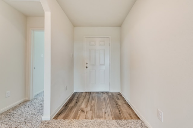 doorway to outside featuring light carpet