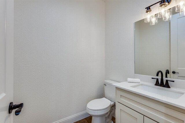 bathroom featuring toilet, wood finished floors, and vanity