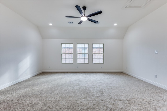 spare room with a ceiling fan, lofted ceiling, visible vents, and baseboards