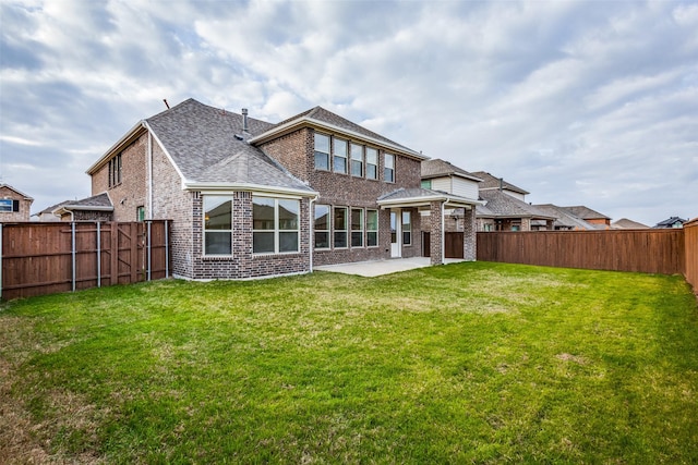 back of house featuring a patio area, a fenced backyard, a lawn, and brick siding