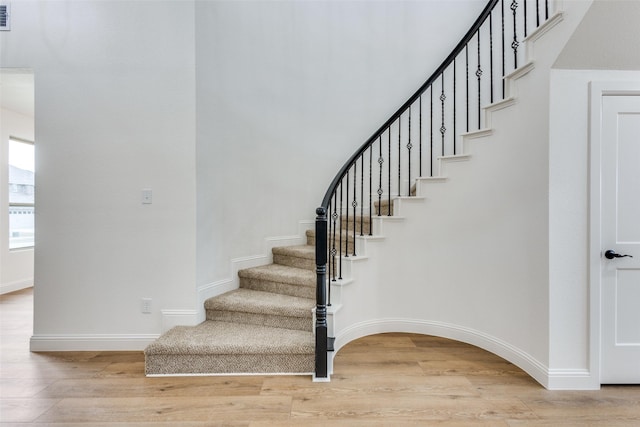 stairs with baseboards and wood finished floors