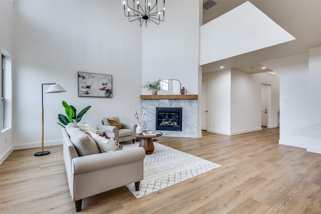 living area with light wood finished floors, a premium fireplace, and baseboards