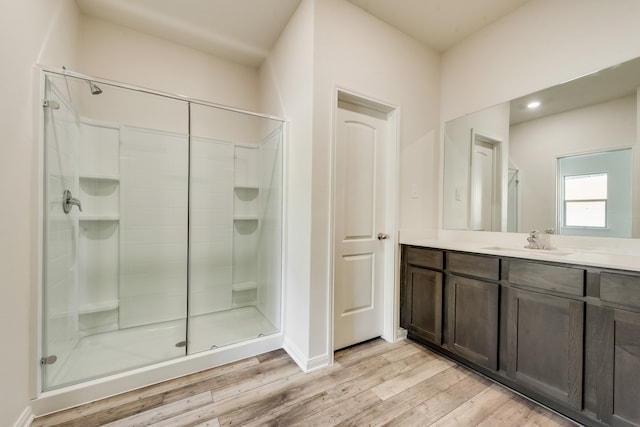 bathroom with hardwood / wood-style floors, vanity, and an enclosed shower