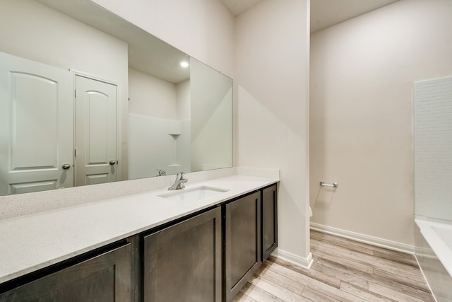 bathroom with hardwood / wood-style floors, vanity, and shower with separate bathtub