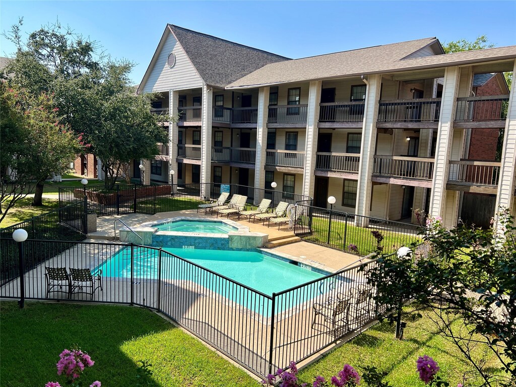 view of swimming pool featuring a yard, a patio, and a hot tub