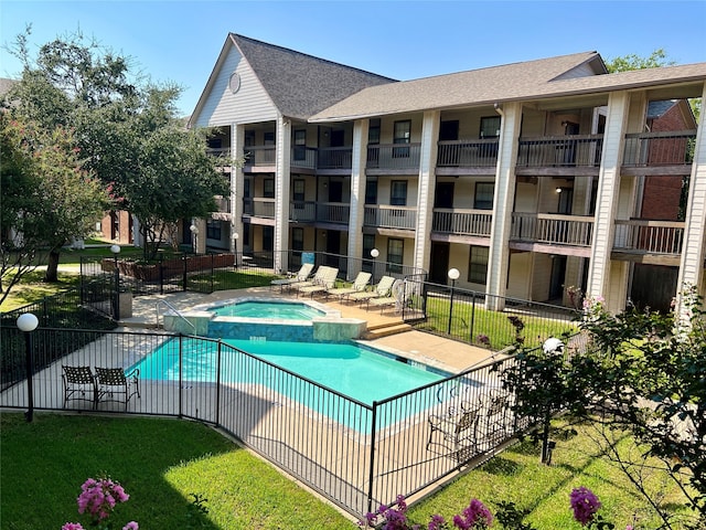 view of swimming pool featuring a yard, a patio, and a hot tub