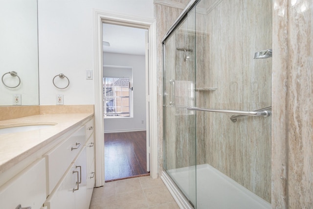 bathroom with tile patterned flooring, vanity, and walk in shower